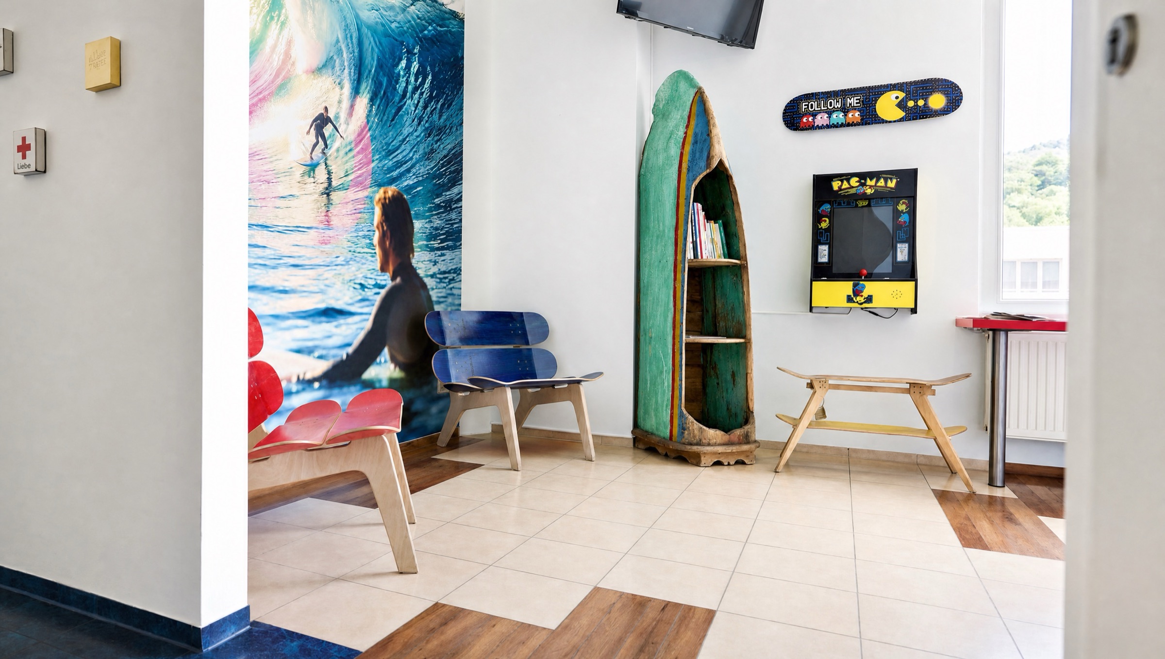 Empfang und Wartebereich mit Surfboard-Regal und Pac-Man-Automat
