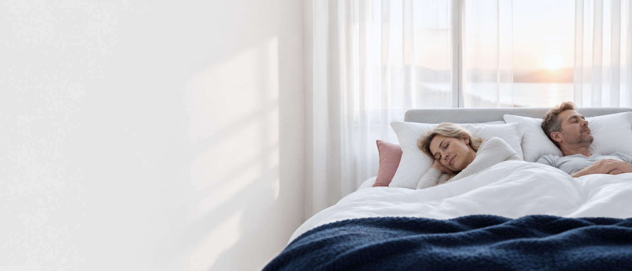 Paar schläft ruhig in einem hellen Schlafzimmer im Morgenlicht